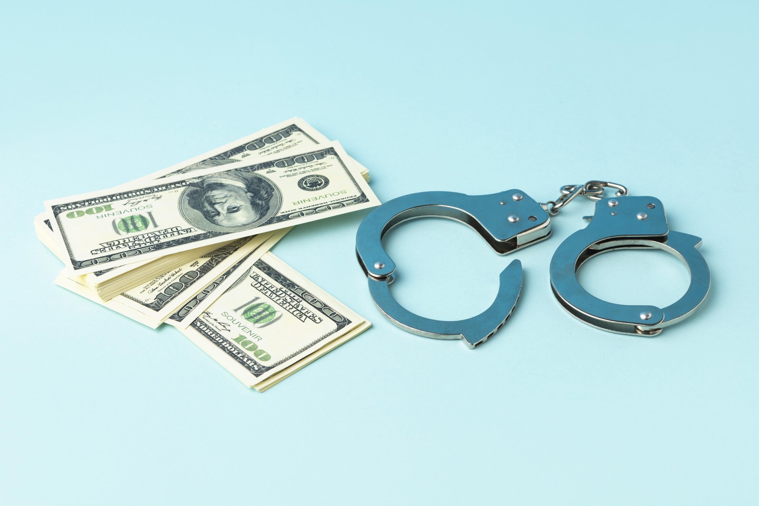 Американские доллары и наручники на голубом фоне